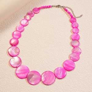 Detail view of pink shell bead necklace with iridescent round sequins and silver clasp