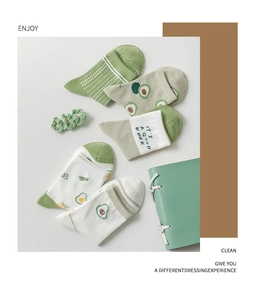 Detail of green cotton socks featuring cute avocado patterns and stripe designs