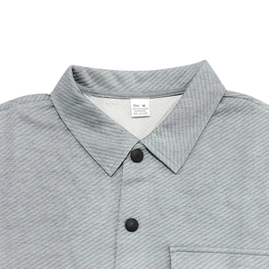 Close-up of the lapel collar and buttons on a light gray heavy twill jacket fabric