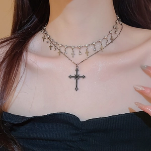 Close-up of vintage double-layer necklace with black cross pendant and rhinestone charms