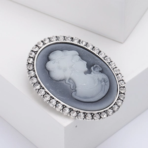 Vintage oval cameo brooch with white female portrait relief and sparkling crystal halo