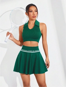 Dettaglio gonna sportiva a pieghe verde in maglia testurizzata con logo GYMWEAR in vita