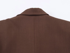 Nahaufnahme der dunkelbraunen Twill-Stoffstruktur an Kragen und Schulter eines Blazers