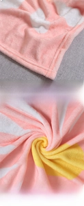 Dettaglio della coperta in flanella rosa e bianca con motivo floreale e consistenza