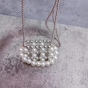 Detail of handcrafted silver beads and white pearls on a mini crossbody bag strap