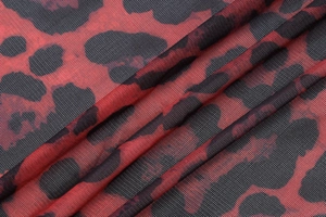 Macro shot of breathable red and black leopard print mesh fabric for sexy summer tops
