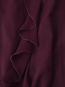 Vista macro del tessuto in chiffon bordeaux scuro con volant e dettagli di pieghe sottili