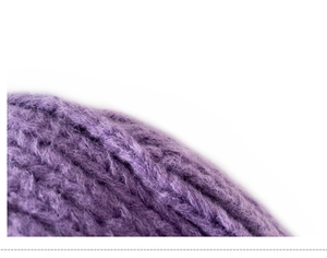 Macro view of the soft purple knitted fabric texture and plush yarn of the children's hat
