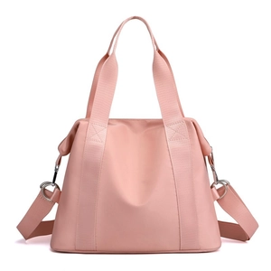 Pink nylon crossbody handbag for women with adjustable strap on white background