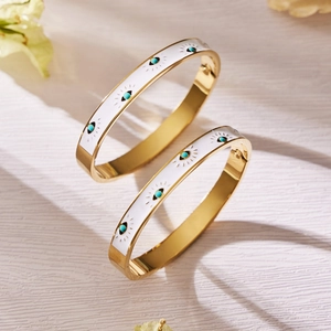 Gold stainless steel evil eye bangle with white enamel inlay and turquoise stone detail