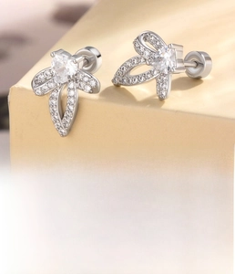 Detail of silver bow stud earring featuring micro-set zircons and a flat screw back