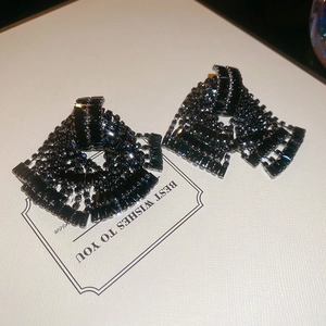 Detailed view of luxury black rhinestone fringe earrings on a white gift card