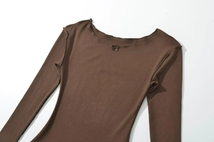 Detailed view of brown ribbed knit top featuring boat neck and delicate bow accents