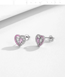 Détail macro de boucles d'oreilles cœur en argent S925 avec émail rose et zircons