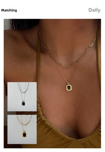 Detail of vintage layered 18k gold plated necklace with black square pendant on a model