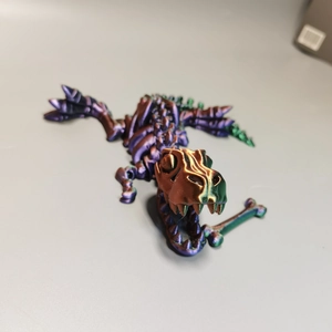 Macro shot of 3D printed T-Rex skull model with bone in mouth and purple green gradient
