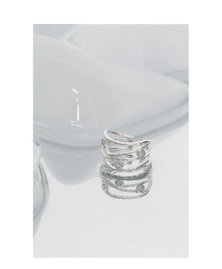 Macro detail of silver layered wrap ring featuring textured lines and sparkling zircons