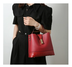 Detail of red bucket bag featuring lychee grain leather and embossed crocodile texture