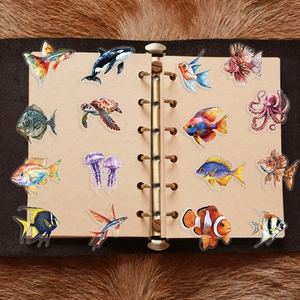 Detailed view of colorful ocean animal stickers on an open notebook with soft plush background