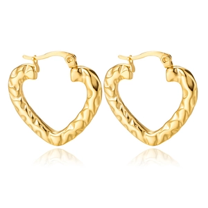 Detail of golden heart-shaped hoop earrings with a textured hammered metal finish