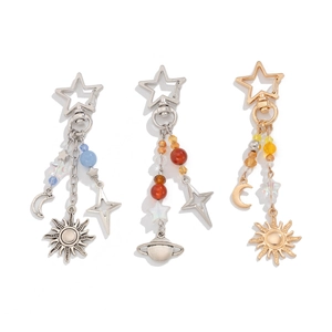 Detailed close-up of gold and silver keychains featuring celestial sun moon and star charms