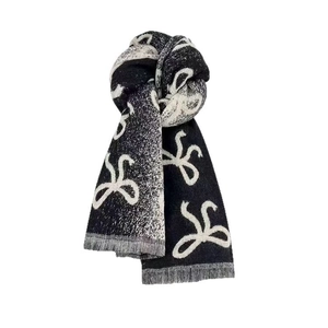 Thick knit scarf with white bow patterns and elegant tassels on a black background