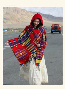 Detail showing red ethnic pattern knit shawl with black tassels in travel outdoor setting