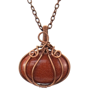 Macro detail of handmade wire wrapped copper pendant with goldstone and metal chain
