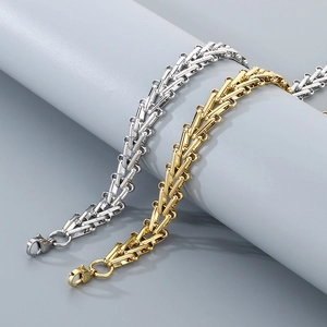 Detail of silver and gold stainless steel triangular curb chain bracelets with lobster clasps