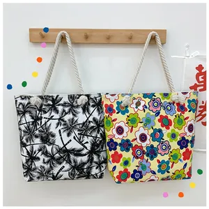 Detail of printed canvas tote bags with thick cotton rope handles hanging on hooks
