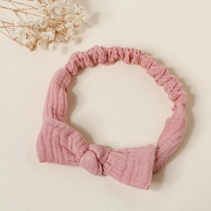 Close-up of pink textured cotton bow headband with elastic wrinkled fabric detail