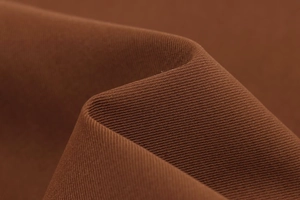 Gros plan sur la texture du tissu sergé marron foncé et le tissage de haute qualité