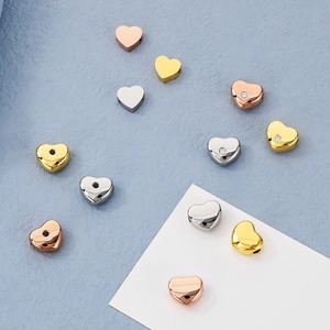 Gros plan de perles en forme de cœur en or, argent et or rose avec de petits diamants