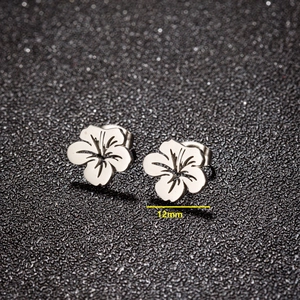 Silver hollow flower earrings in stainless steel with 12mm diameter on black background