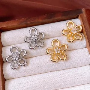 Exquisite hollow flower stud earrings in gold and silver finish with zircon centers