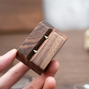 Macro shot of a vintage square walnut wood ring box with gold metal hinges