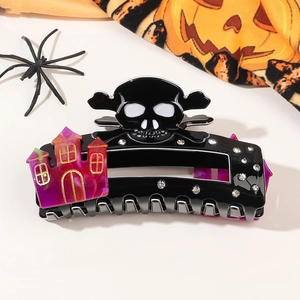 Detail of Halloween hair claw with black skull and purple marble haunted house pattern