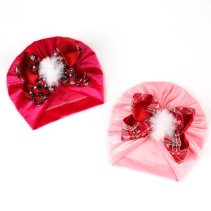 Detail of baby velvet turbans with red plaid bows and soft white fuzzy pom poms