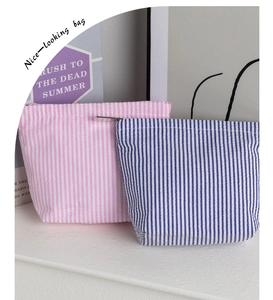 Close-up of pink and blue seersucker striped cosmetic bags with durable metal zippers