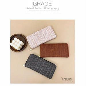 Detailed macro view of three textured fabric long wallets with gold metal zippers and zip closure