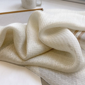 White silk wool blend scarf with gold striped edges and elegant pleated texture