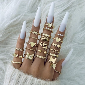 Goldenes Ring-Set mit Schmetterling, Perle, Herz und Blatt-Motiven an der Hand