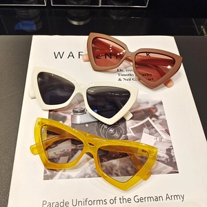 Detailed view of three vintage cat eye sunglasses on a fashion magazine background