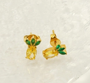 Detailed view of pineapple stud earrings with yellow cubic zirconia and gold plating