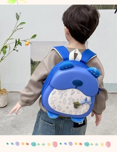Close-up of blue cartoon animal backpack with 3D plush ears and cute acorn zipper charm
