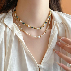 Close-up of double-layered beaded necklace with colorful stones and a baroque pearl on model
