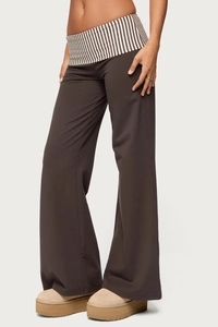Detail of loose brown wide leg pants featuring a black and white striped folded waistband