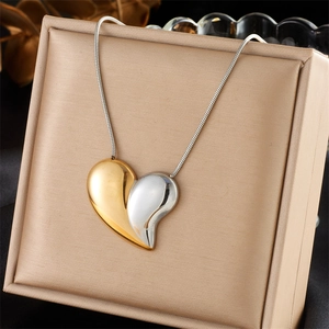 Two-tone heart pendant necklace in gold and silver finish on elegant jewelry box