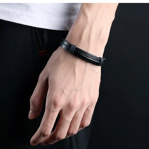 Close-up of a double-layer black leather bracelet on a male wrist showing texture