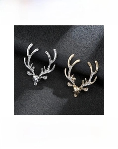Detailed close-up of golden and silver Christmas reindeer brooches with inset rhinestones